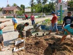 Sinergi Dengan Masyarakat, Babinsa Koramil 1307-01/Poso Kota Laksanakan Kerja Bakti di Halaman Kantor Desa Sintuwulemba